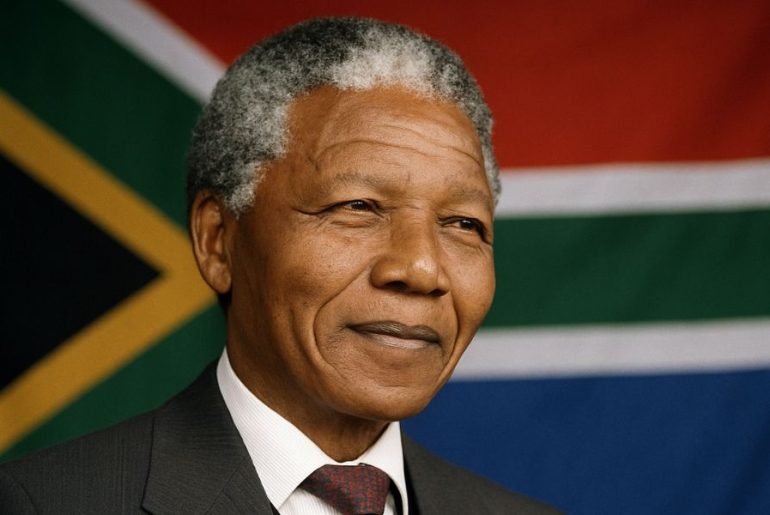 AI generated image of Nelson Mandela smiling in front of the South African flag
