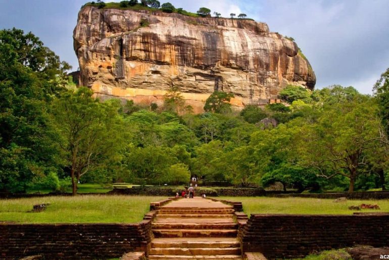 Front view of Sigiriya Rock Fortress surrounded by green gardens in Sri Lanka