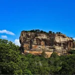 Front view of Sigiriya Rock Fortress surrounded by green gardens in Sri Lanka